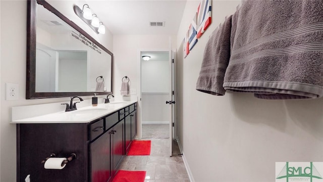 full bath with double vanity, a sink, baseboards, and visible vents