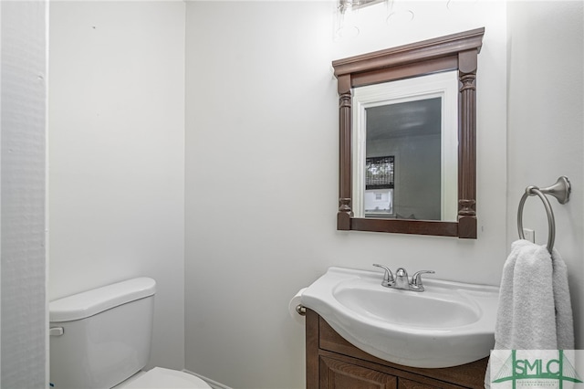 half bath featuring vanity and toilet