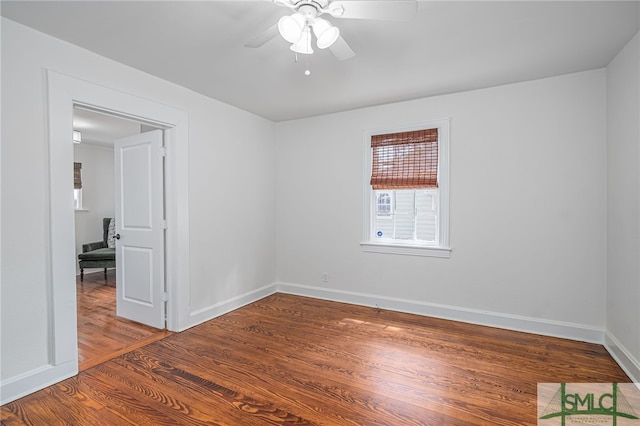 spare room featuring baseboards, a ceiling fan, and wood finished floors