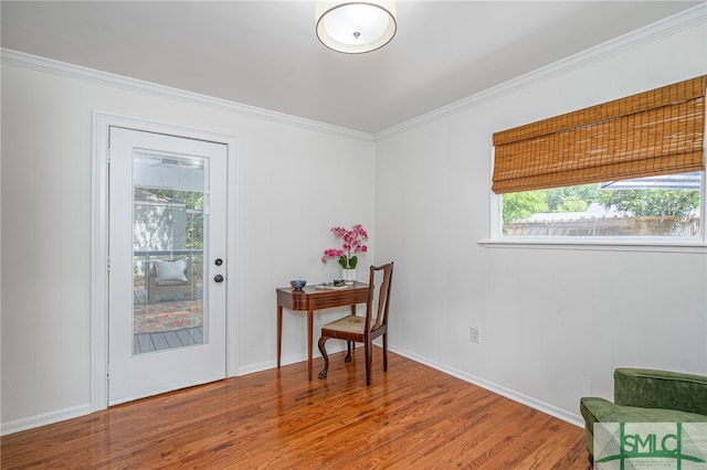interior space with baseboards, ornamental molding, and wood finished floors