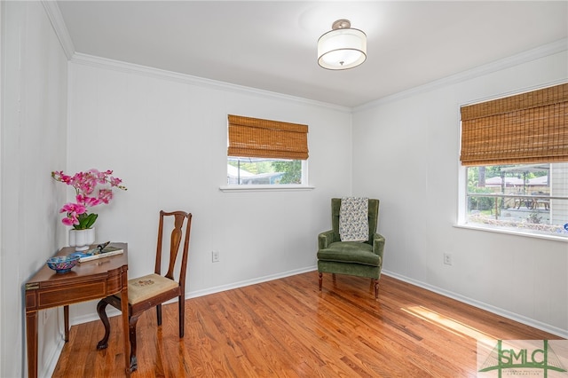 sitting room with crown molding, baseboards, and wood finished floors