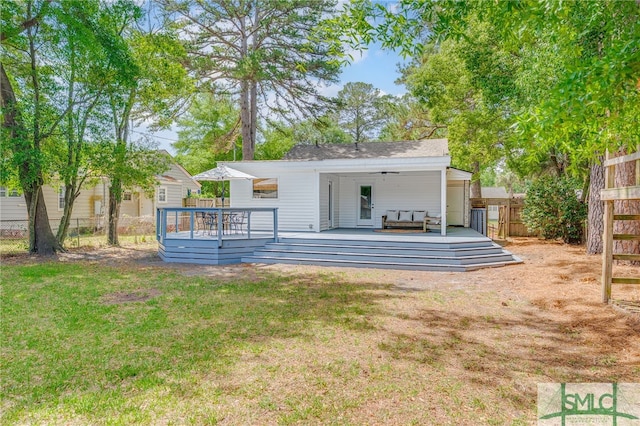 back of house featuring a fenced backyard, ceiling fan, a yard, and a deck