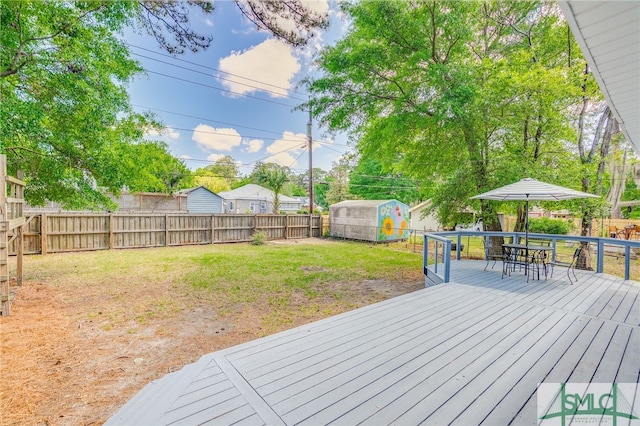 wooden deck with a fenced backyard, outdoor dining area, and a lawn