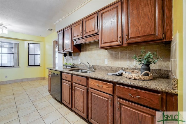 kitchen with visible vents, light tile patterned flooring, dishwashing machine, a sink, and backsplash