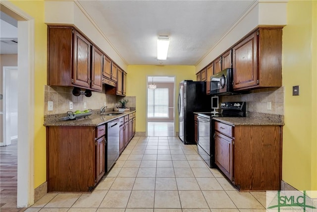 kitchen with light tile patterned floors, appliances with stainless steel finishes, a sink, and tasteful backsplash