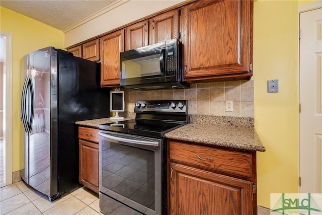 kitchen with brown cabinets, a textured ceiling, stainless steel appliances, decorative backsplash, and light tile patterned floors