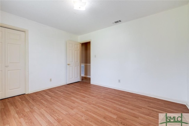 unfurnished room with light wood-style floors, baseboards, and visible vents