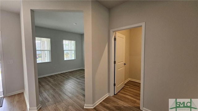 hall with baseboards and wood finished floors