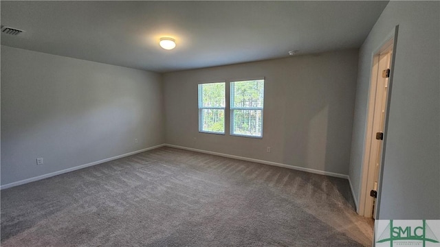 empty room with carpet floors, baseboards, and visible vents
