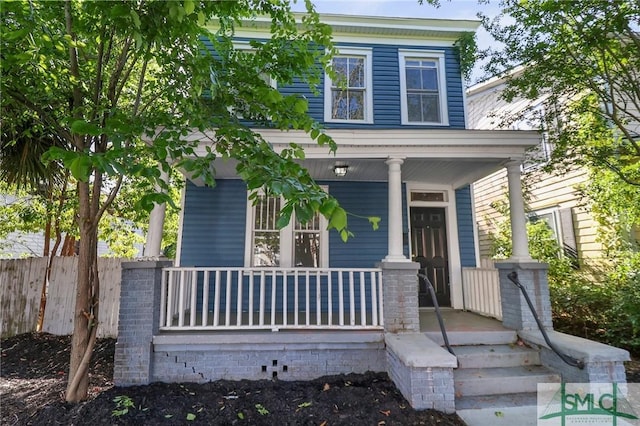 view of front facade featuring a porch and fence