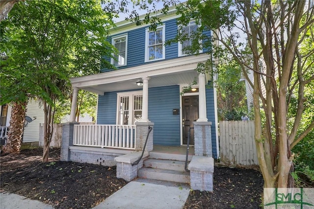 view of front facade featuring a porch and fence