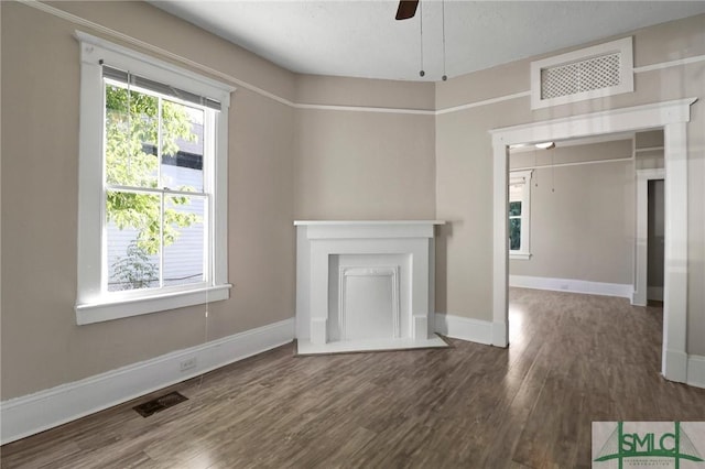 unfurnished living room featuring baseboards, a ceiling fan, wood finished floors, and visible vents