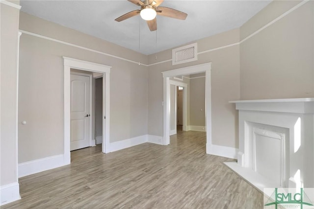unfurnished living room featuring baseboards, ceiling fan, visible vents, and wood finished floors