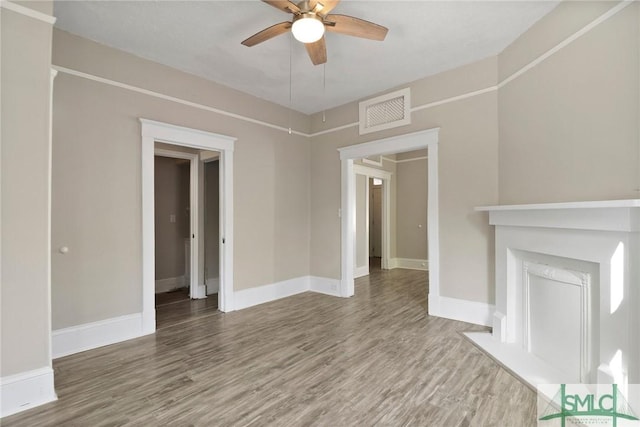 unfurnished living room featuring visible vents, baseboards, ceiling fan, and wood finished floors