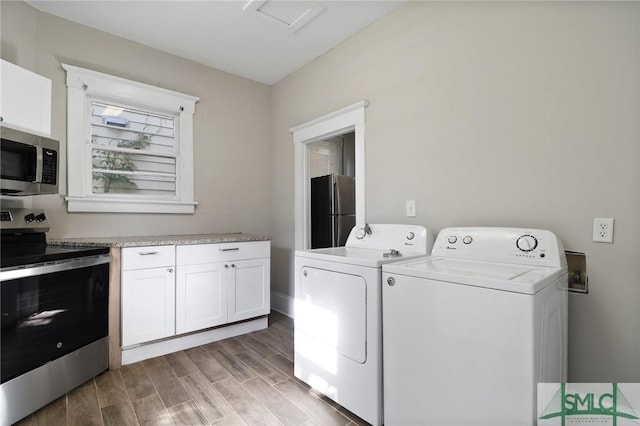 washroom featuring separate washer and dryer, laundry area, and light wood-type flooring
