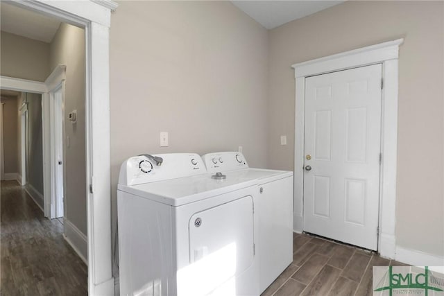 laundry room featuring baseboards, laundry area, dark wood-style flooring, and washing machine and clothes dryer