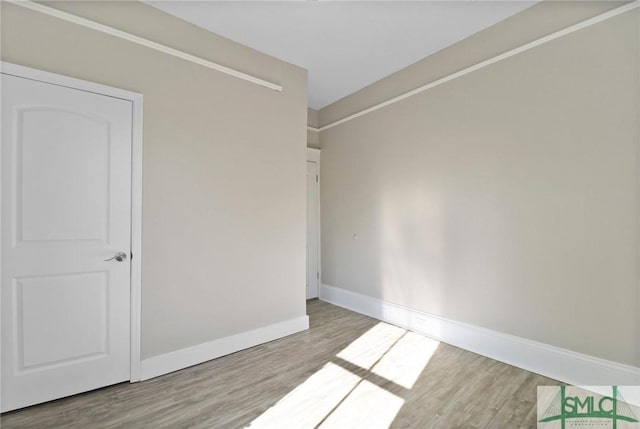 empty room featuring baseboards and wood finished floors