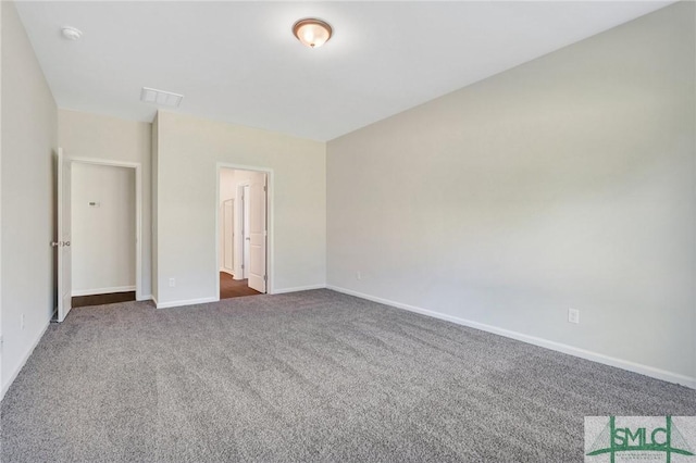 unfurnished bedroom with baseboards, visible vents, and dark carpet
