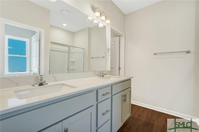 full bathroom with a sink, baseboards, a stall shower, and wood finished floors