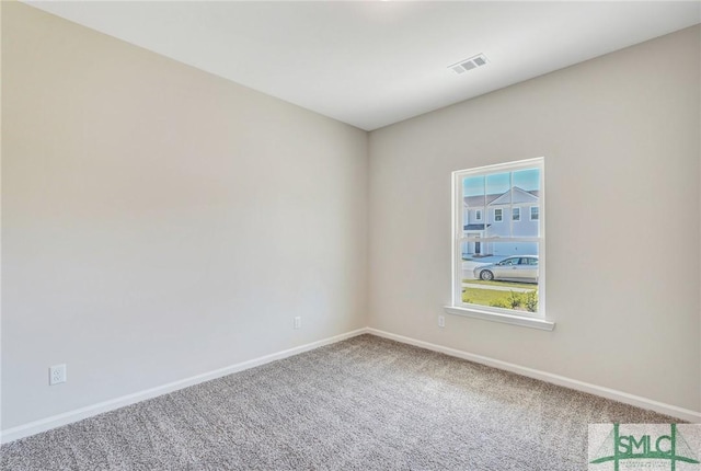 empty room featuring visible vents, carpet, and baseboards