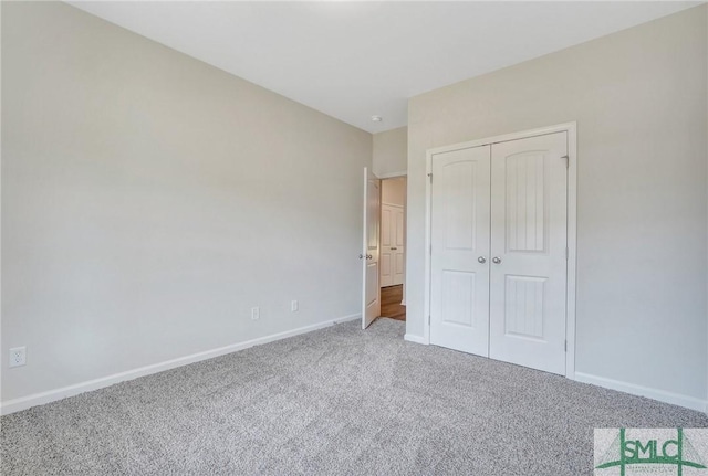 unfurnished bedroom with carpet floors, baseboards, and a closet