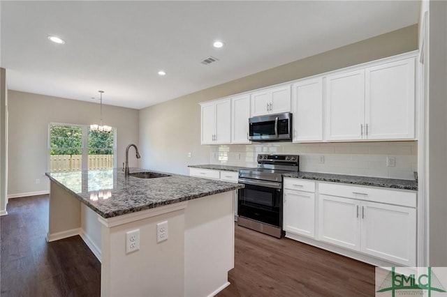 kitchen featuring dark wood-style flooring, visible vents, tasteful backsplash, a sink, and stainless steel appliances