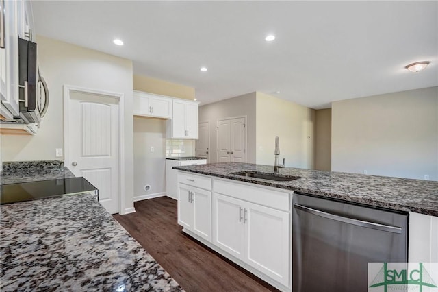 kitchen featuring white cabinets, dark wood-style flooring, appliances with stainless steel finishes, a sink, and dark stone counters