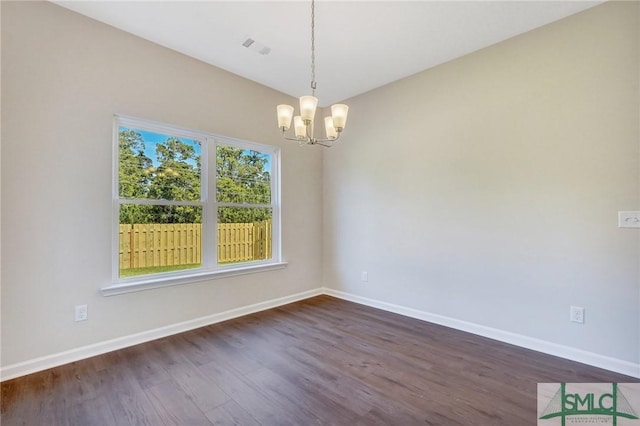 unfurnished room featuring dark wood-style flooring, baseboards, and a chandelier