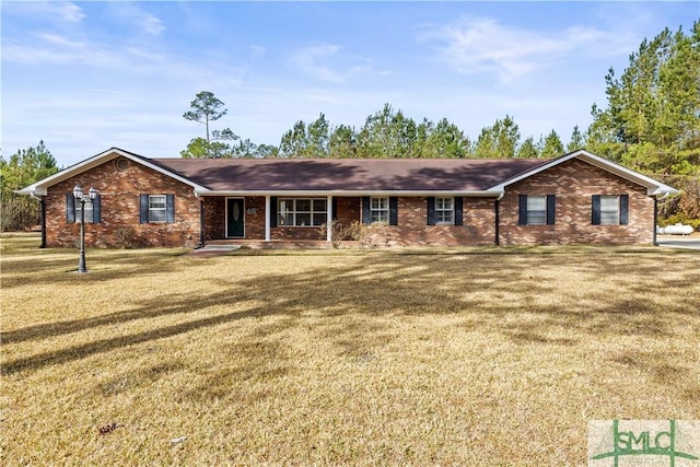 single story home featuring brick siding, a front lawn, and covered porch