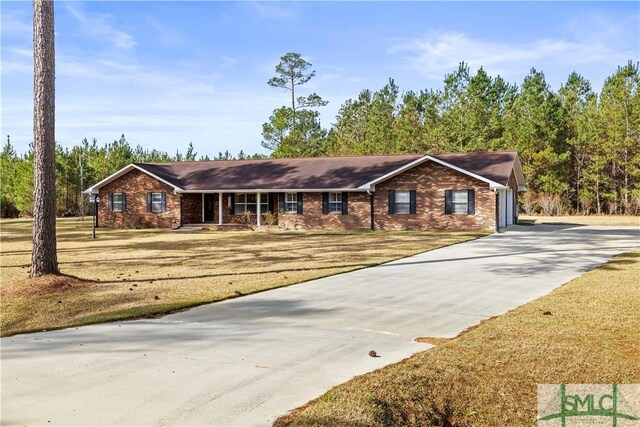 ranch-style house with a porch, a front lawn, brick siding, and concrete driveway