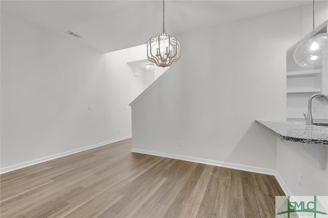 127 Lower Creek Dr, Richmond Hill, GA 31324 - unfurnished dining area with visible vents, baseboards, wood finished floors, and a notable chandelier