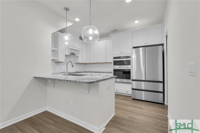 127 Lower Creek Dr, Richmond Hill, GA 31324 - kitchen featuring visible vents, a peninsula, recessed lighting, white cabinets, and stainless steel appliances