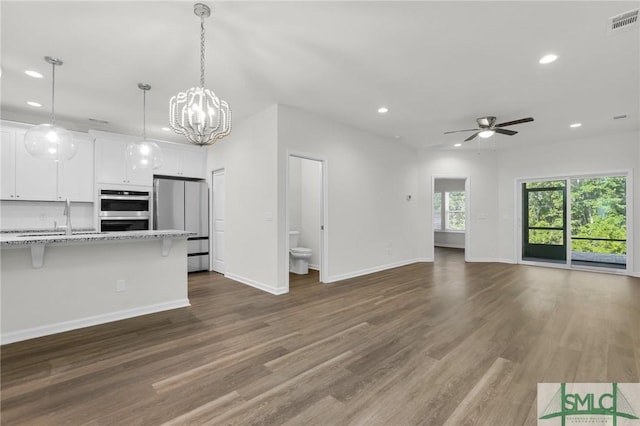 127 Lower Creek Dr, Richmond Hill, GA 31324 - unfurnished living room with recessed lighting, visible vents, ceiling fan with notable chandelier, and dark wood-type flooring