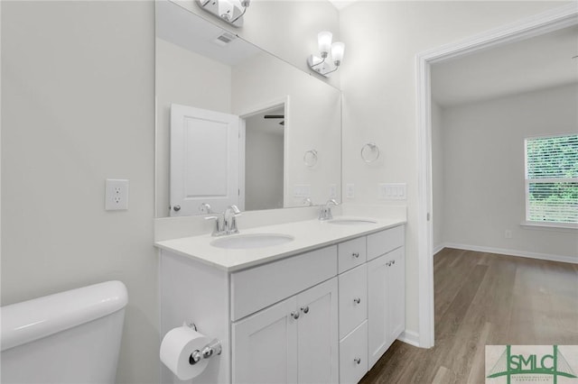 127 Lower Creek Dr, Richmond Hill, GA 31324 - bathroom featuring a sink, double vanity, toilet, and wood finished floors