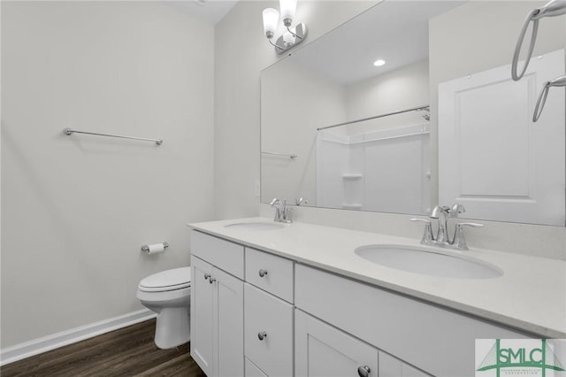 127 Lower Creek Dr, Richmond Hill, GA 31324 - full bath with baseboards, a sink, wood finished floors, and toilet