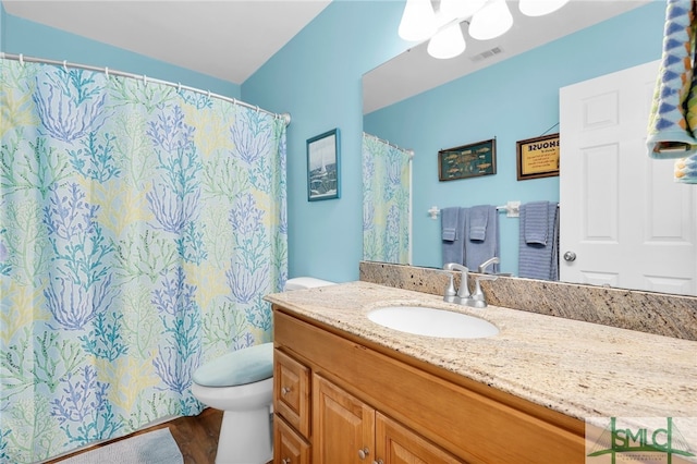 106 Pelican Ct, Tybee Island, GA 31328 - full bathroom with vanity, toilet, wood finished floors, a shower with curtain, and visible vents