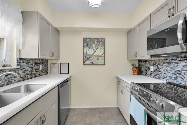106 Pelican Ct, Tybee Island, GA 31328 - kitchen featuring gray cabinetry, appliances with stainless steel finishes, decorative backsplash, and a sink