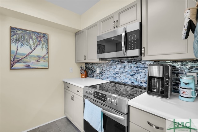 106 Pelican Ct, Tybee Island, GA 31328 - kitchen with gray cabinetry, light countertops, tasteful backsplash, and stainless steel appliances