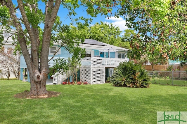 106 Pelican Ct, Tybee Island, GA 31328 - exterior space with a lawn, fence, solar panels, and stairway