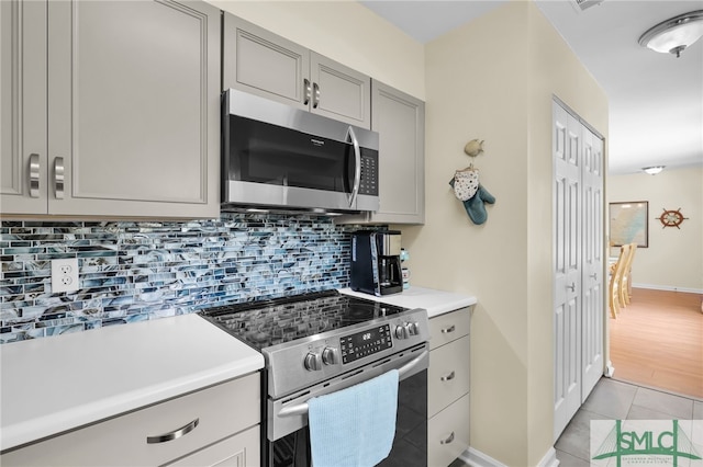 106 Pelican Ct, Tybee Island, GA 31328 - kitchen featuring gray cabinets, appliances with stainless steel finishes, tasteful backsplash, light countertops, and light tile patterned floors