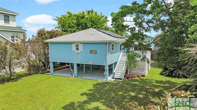 106 Pelican Ct, Tybee Island, GA 31328 - back of property with stairway, a yard, roof with shingles, and a carport