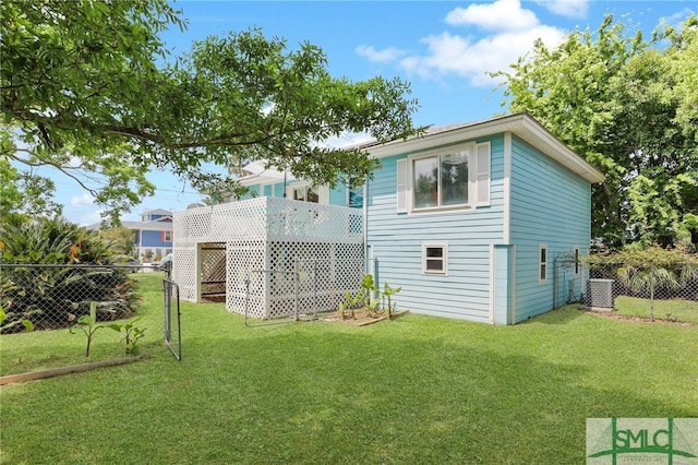 106 Pelican Ct, Tybee Island, GA 31328 - rear view of house featuring a fenced backyard, a lawn, and cooling unit