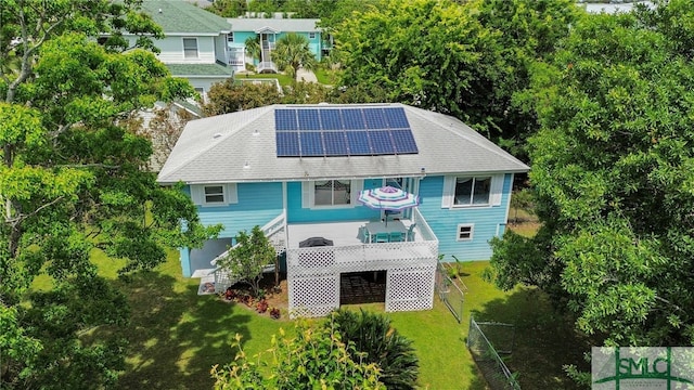 106 Pelican Ct, Tybee Island, GA 31328 - rear view of property with roof mounted solar panels, a yard, and stairway