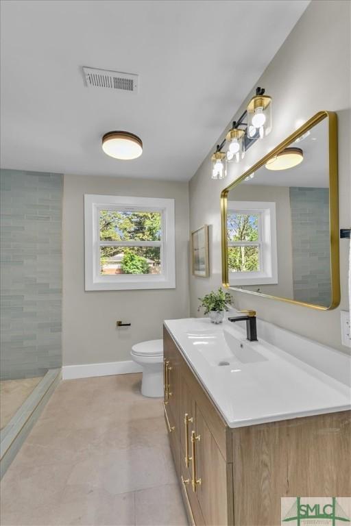 1107 E Derenne Ave, Savannah, GA 31406 - full bathroom with visible vents, vanity, baseboards, toilet, and tiled shower