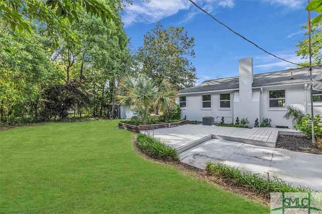 1107 E Derenne Ave, Savannah, GA 31406 - rear view of property featuring stucco siding, a chimney, cooling unit, a patio area, and a yard