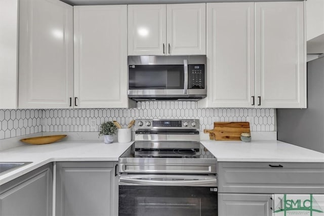 1107 E Derenne Ave, Savannah, GA 31406 - kitchen with light countertops, decorative backsplash, white cabinets, and stainless steel appliances