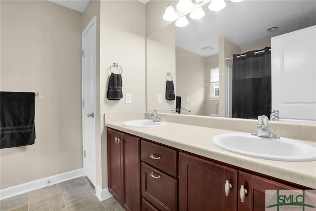 bathroom featuring double vanity, baseboards, curtained shower, and a sink