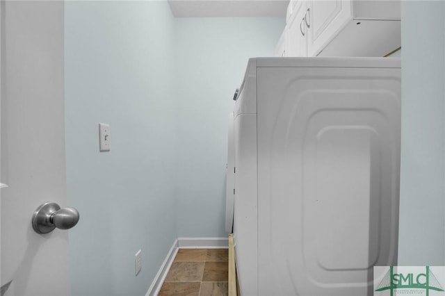 laundry room with laundry area, stone finish flooring, and baseboards