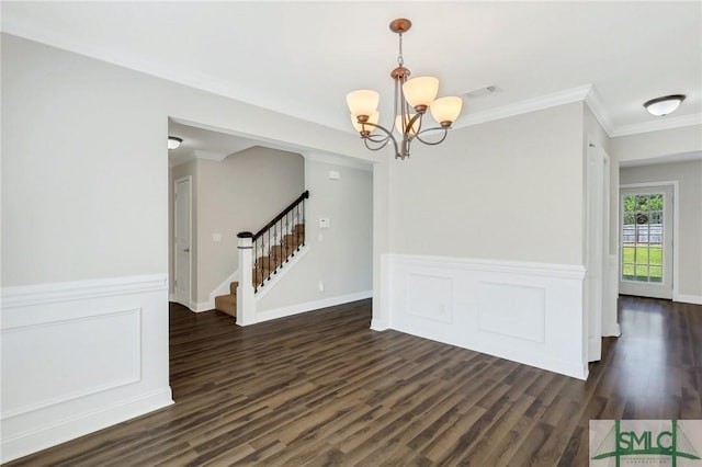 unfurnished dining area with crown molding, a notable chandelier, wainscoting, dark wood finished floors, and stairway