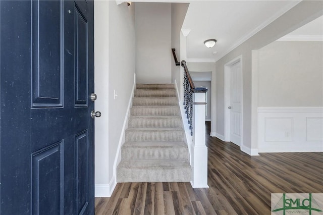 stairs with crown molding, baseboards, and wood finished floors